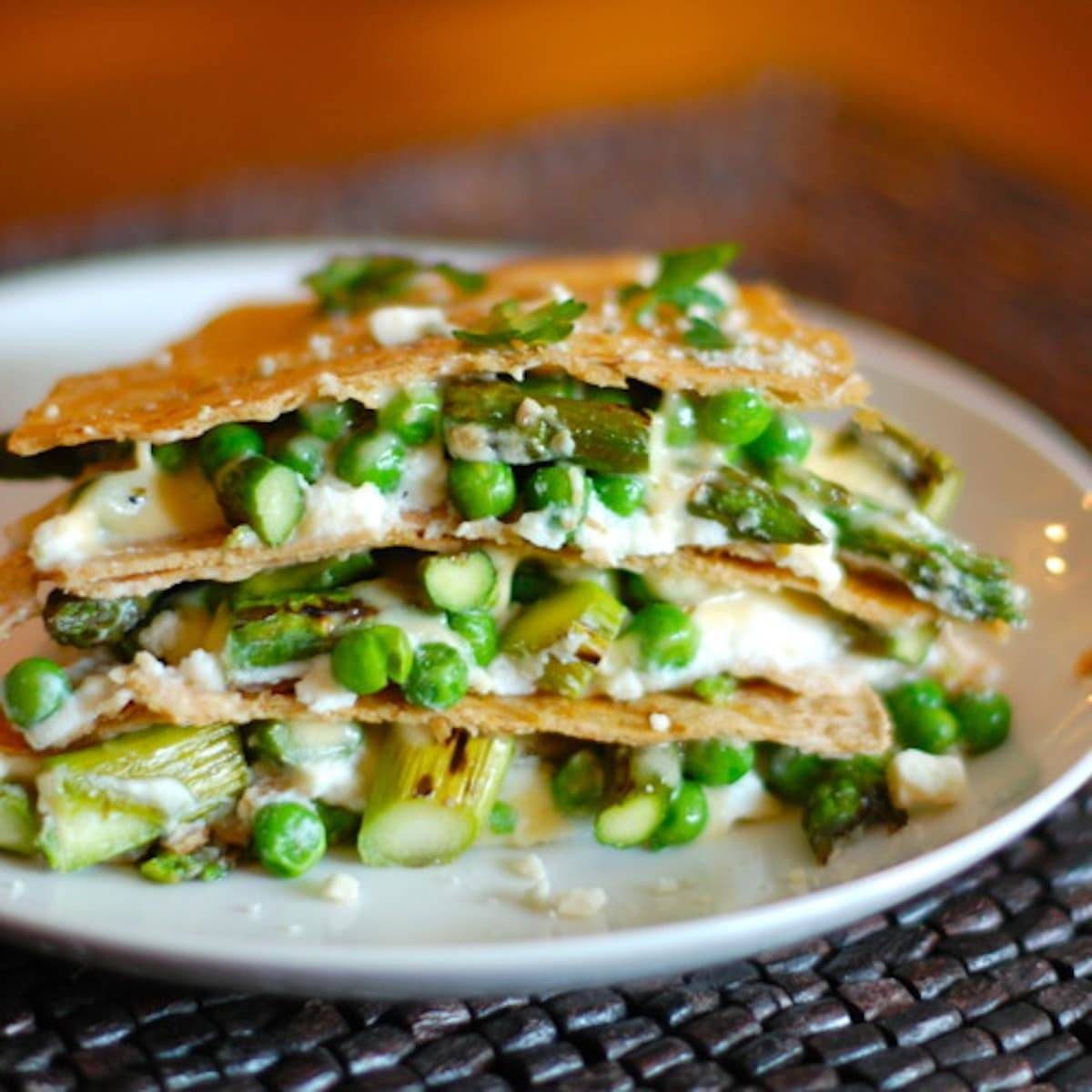 Asparagus quesadilla lasagna stacked on a white plate.
