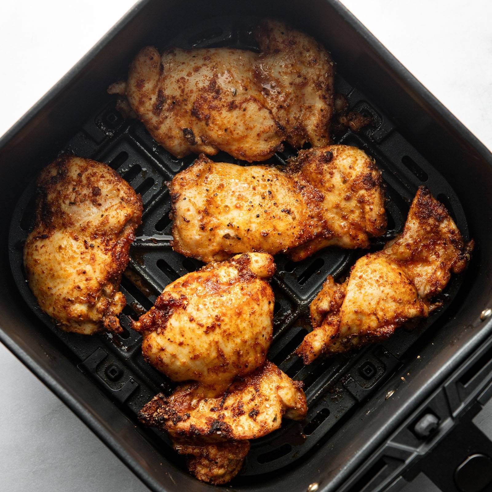 Chicken thighs in an air fryer.