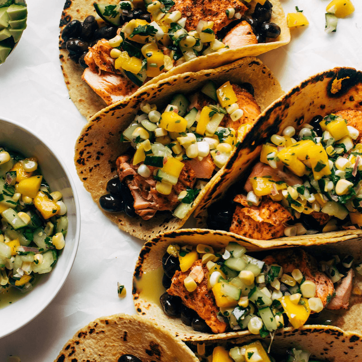 Salmon tacos topped with mango corn salsa.