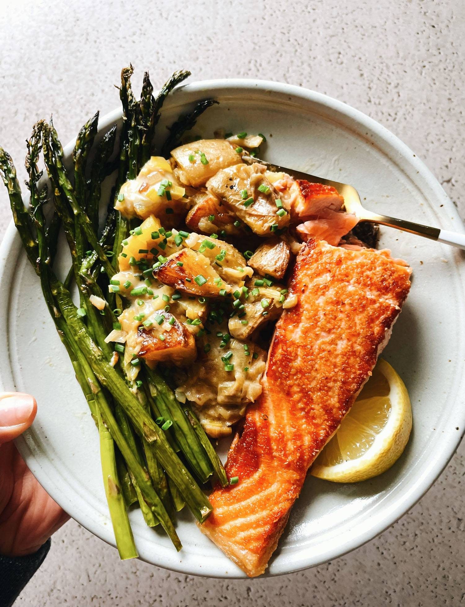 Salmon on a plate with potatoes and asparagus.