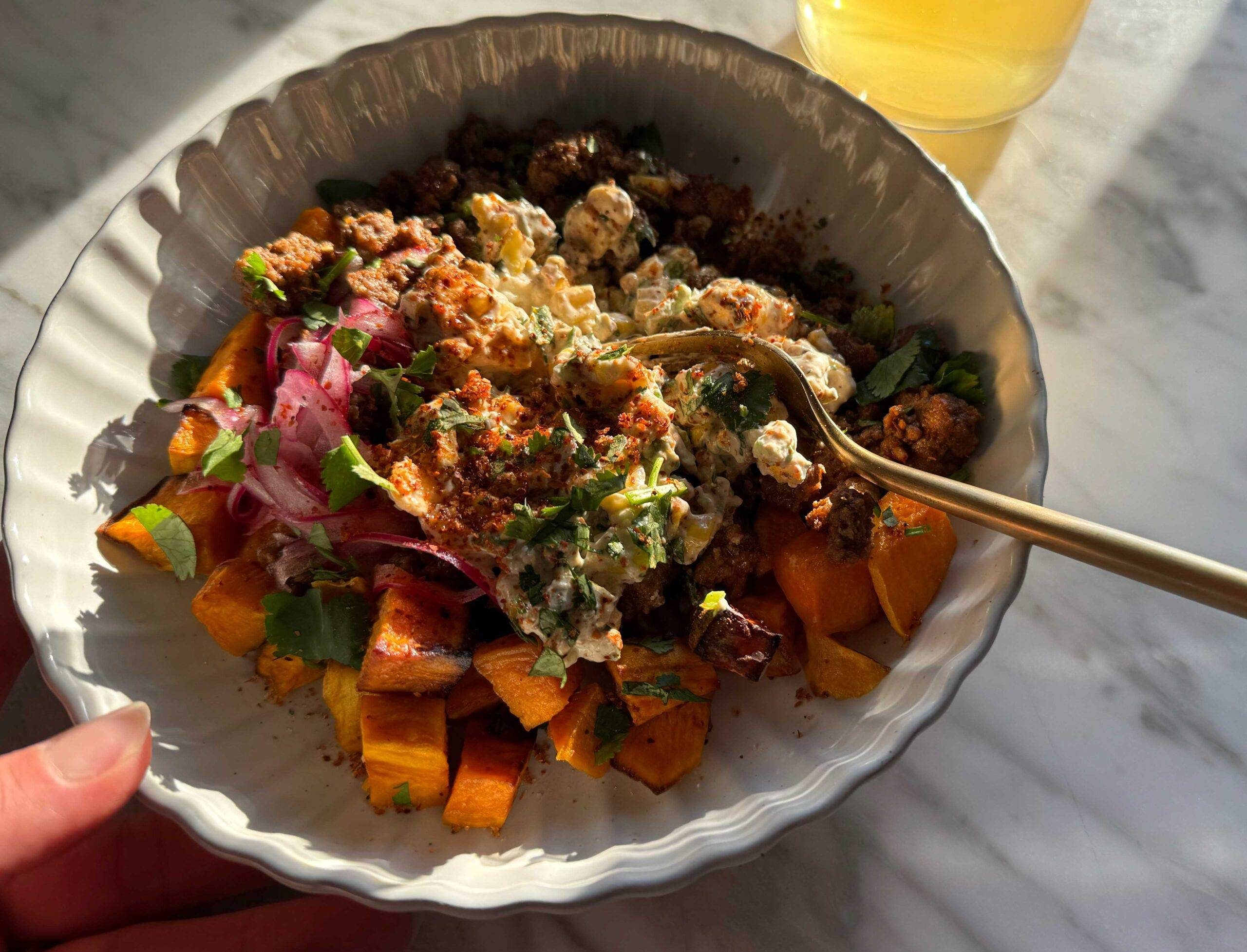 Sweet potatoes in a bowl with beef and street corn dip.