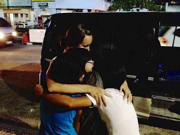 Woman hugging children.