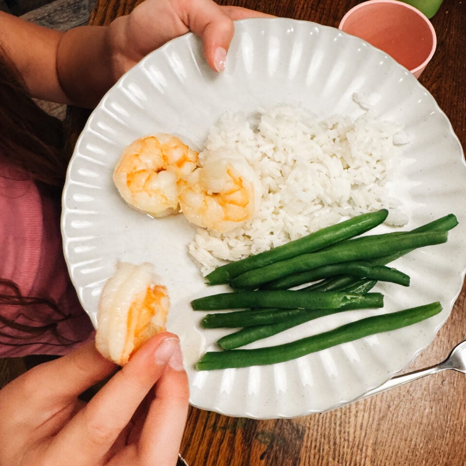 Shrimp, rice, and green beans on a plate.