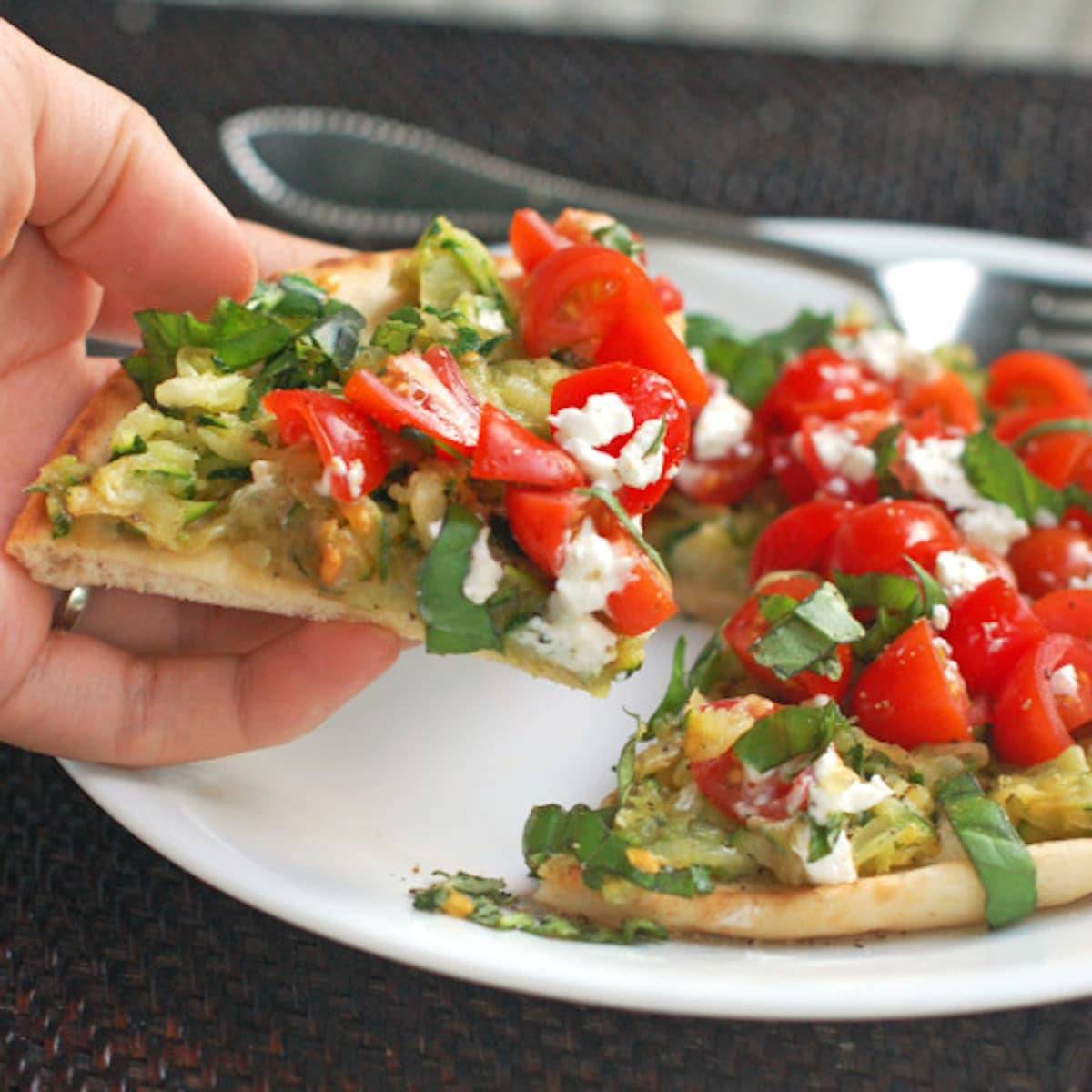 Flatbread pizza with zucchini, cherry tomatoes, and basil.