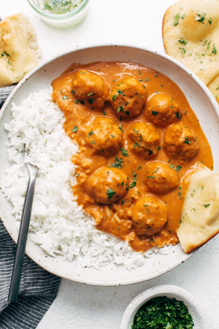 Butter chicken meatballs in a bowl with rice.