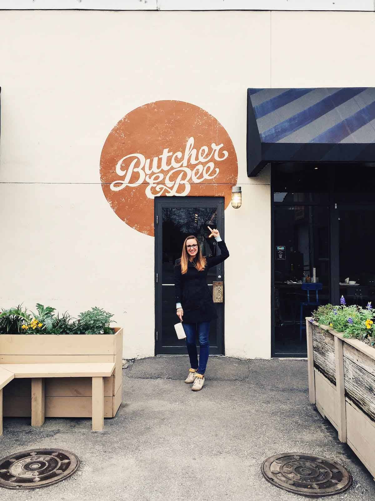 Butcher and bee sign with a woman pointing to it.